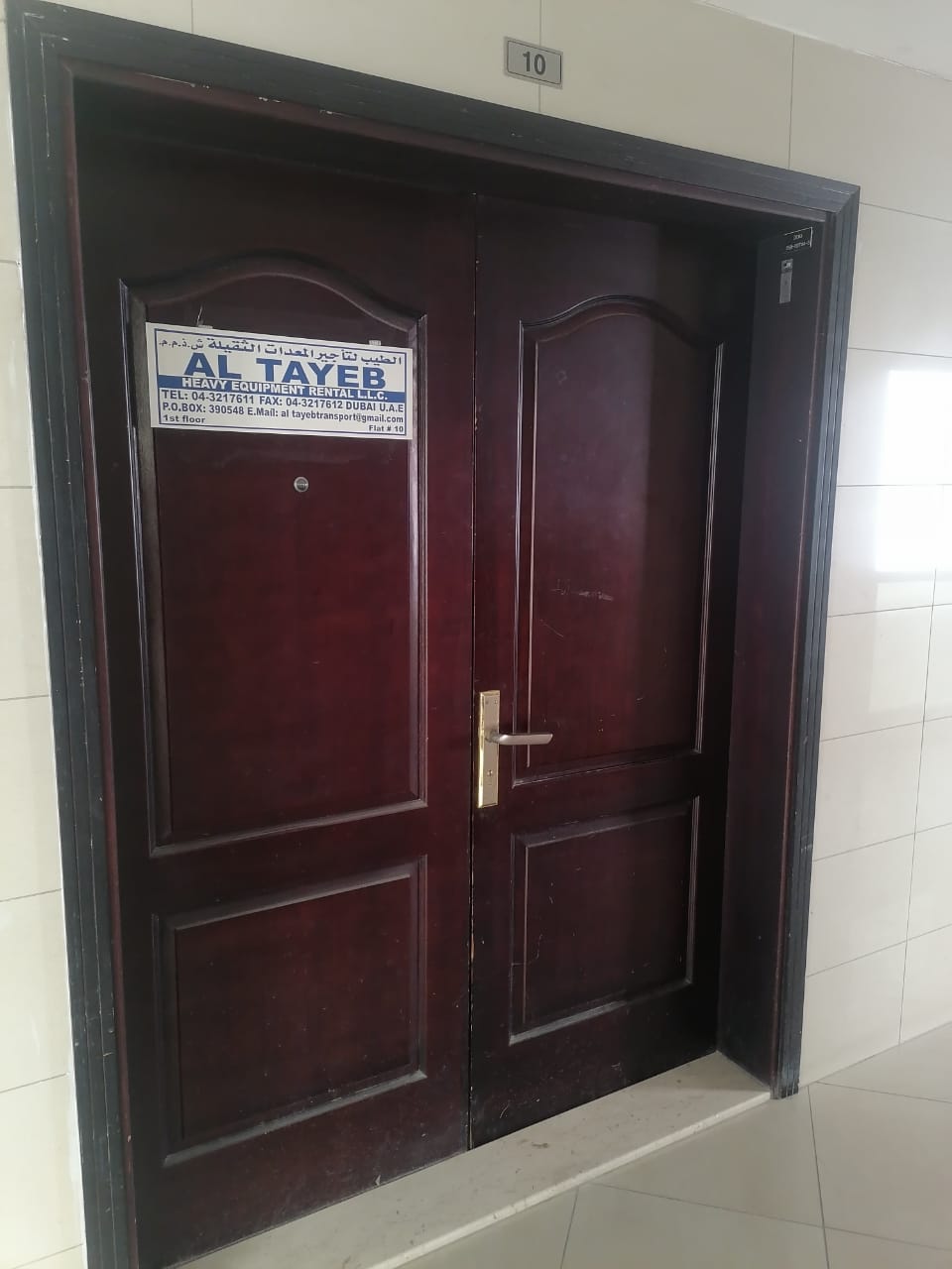 AL TAYEB office entrance door with company sign